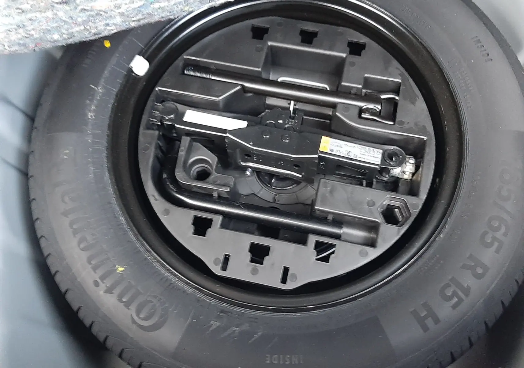 Gros plan sur la roue de secours et le kit d'outils de la Renault Clio V TCE 90CH Evolution 2025, gris schiste.