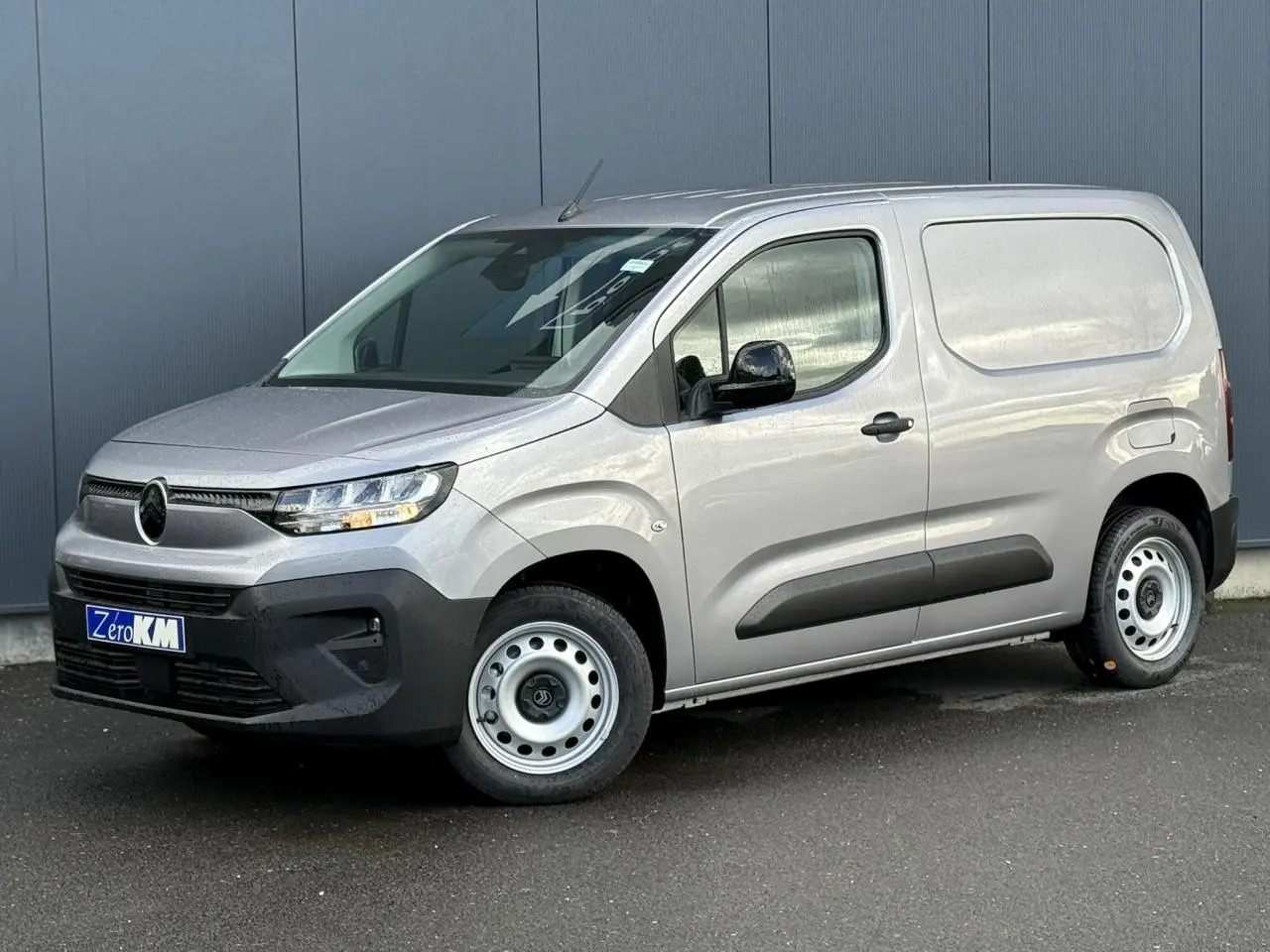 Vue 3/4 avant droit d'un Citroën Berlingo Van gris Artense avec jantes tôles et pare-chocs noirs.