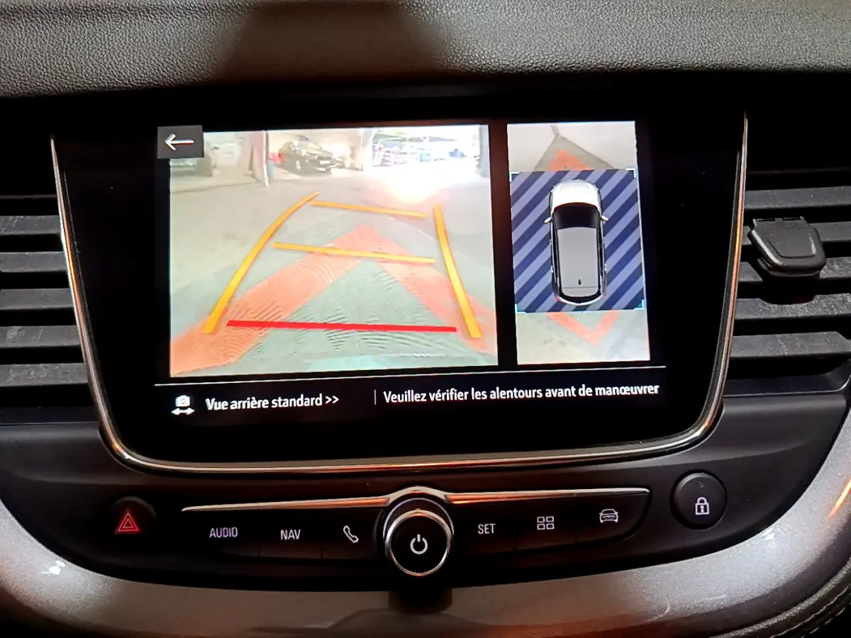 Écran tactile intérieur montrant la caméra de recul et l'aide au stationnement du tableau de bord de l'Opel Grandland X noir.