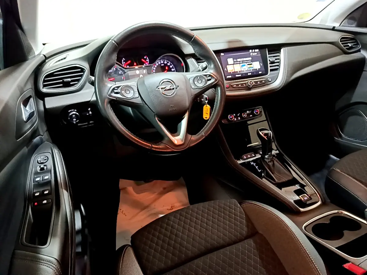 Intérieur noir de l'Opel Grandland X 2021, vue du poste de conduite avec volant cuir et écran tactile central.