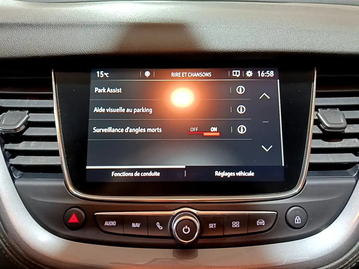 Écran tactile central du tableau de bord de l’Opel Grandland X noir, affichant les aides au stationnement et angles morts.