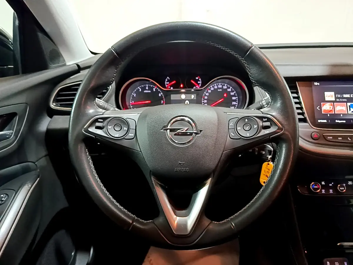 Intérieur noir de l'Opel Grandland X 2021, vue centrée sur le volant cuir et le tableau de bord avec écran tactile.