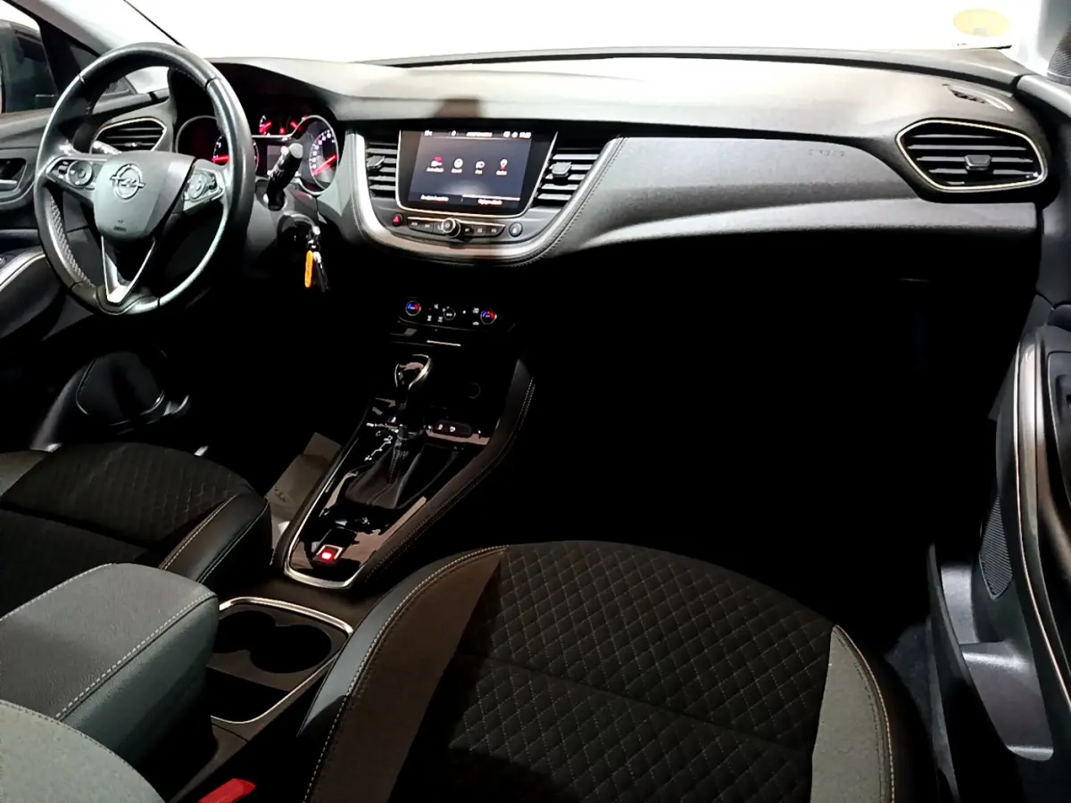 Intérieur noir de l’Opel Grandland X 2021, vue du tableau de bord et console centrale avec écran tactile et volant multifonctions.