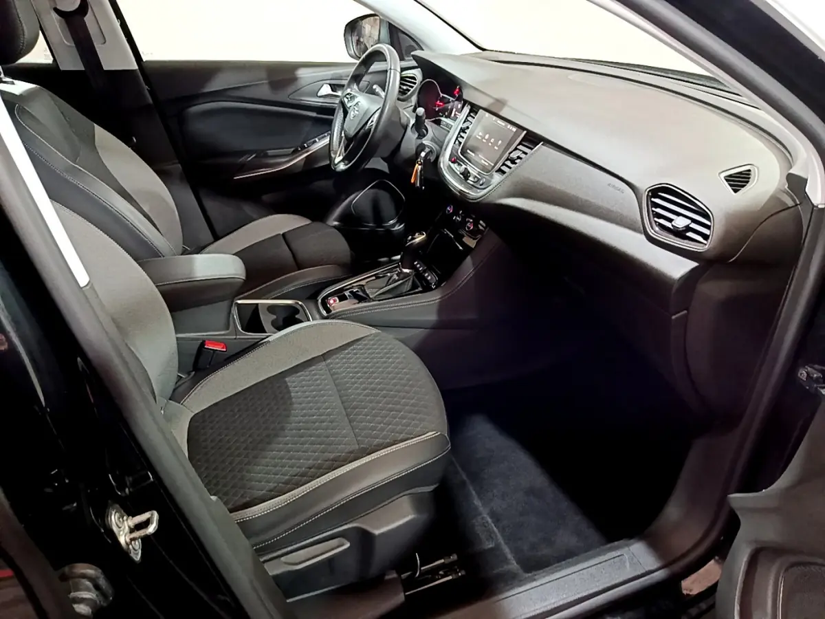 Intérieur avant droit de l'Opel Grandland X 1.5 Diesel 130 Elegance Business, sièges gris et tableau de bord moderne.