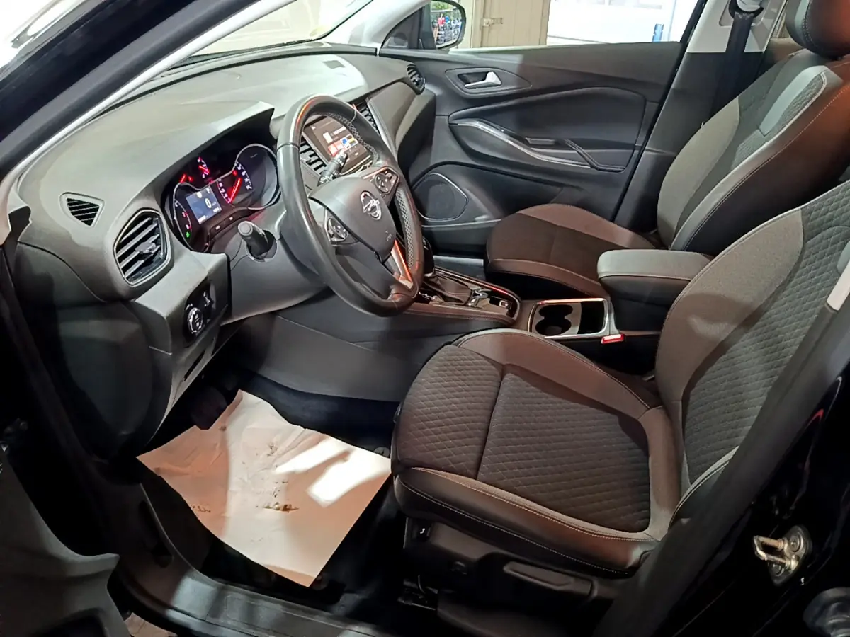 Intérieur avant droit de l’Opel Grandland X 2021 avec sièges tissu noir et tableau de bord moderne équipé d’un écran tactile.