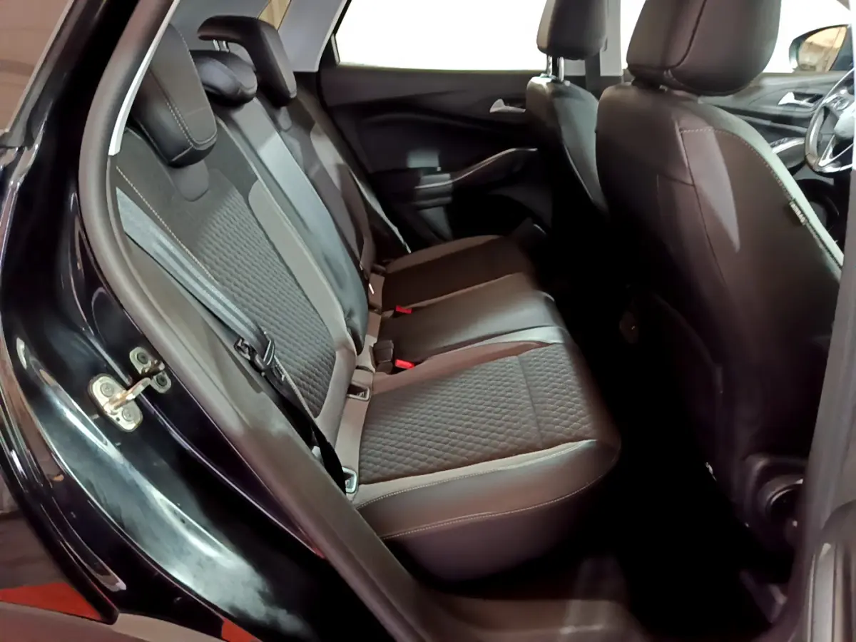 Vue intérieure côté gauche sur la banquette arrière en tissu gris et noir du Opel Grandland X noir 2021.