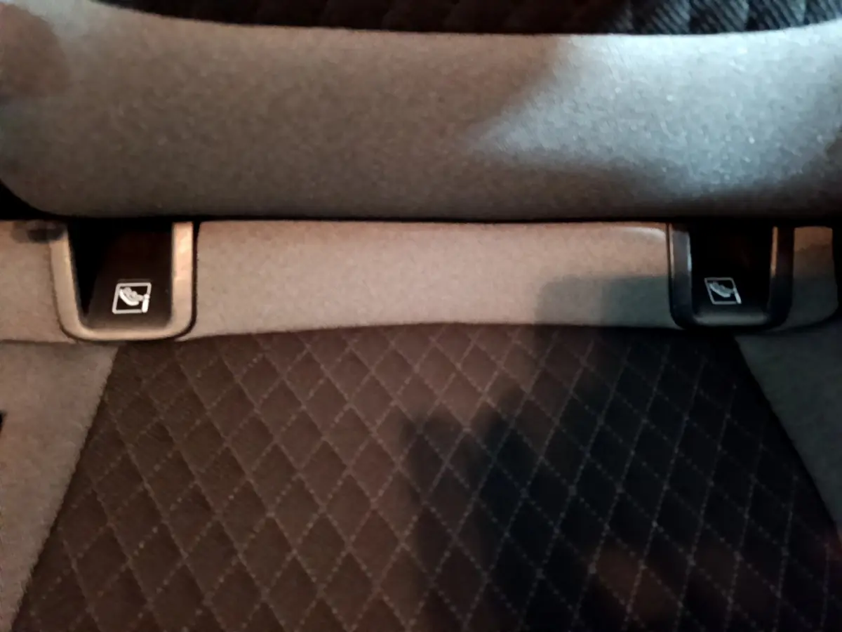 Gros plan sur les commandes de rabattement des sièges arrière du coffre du SUV Opel Grandland X noir.