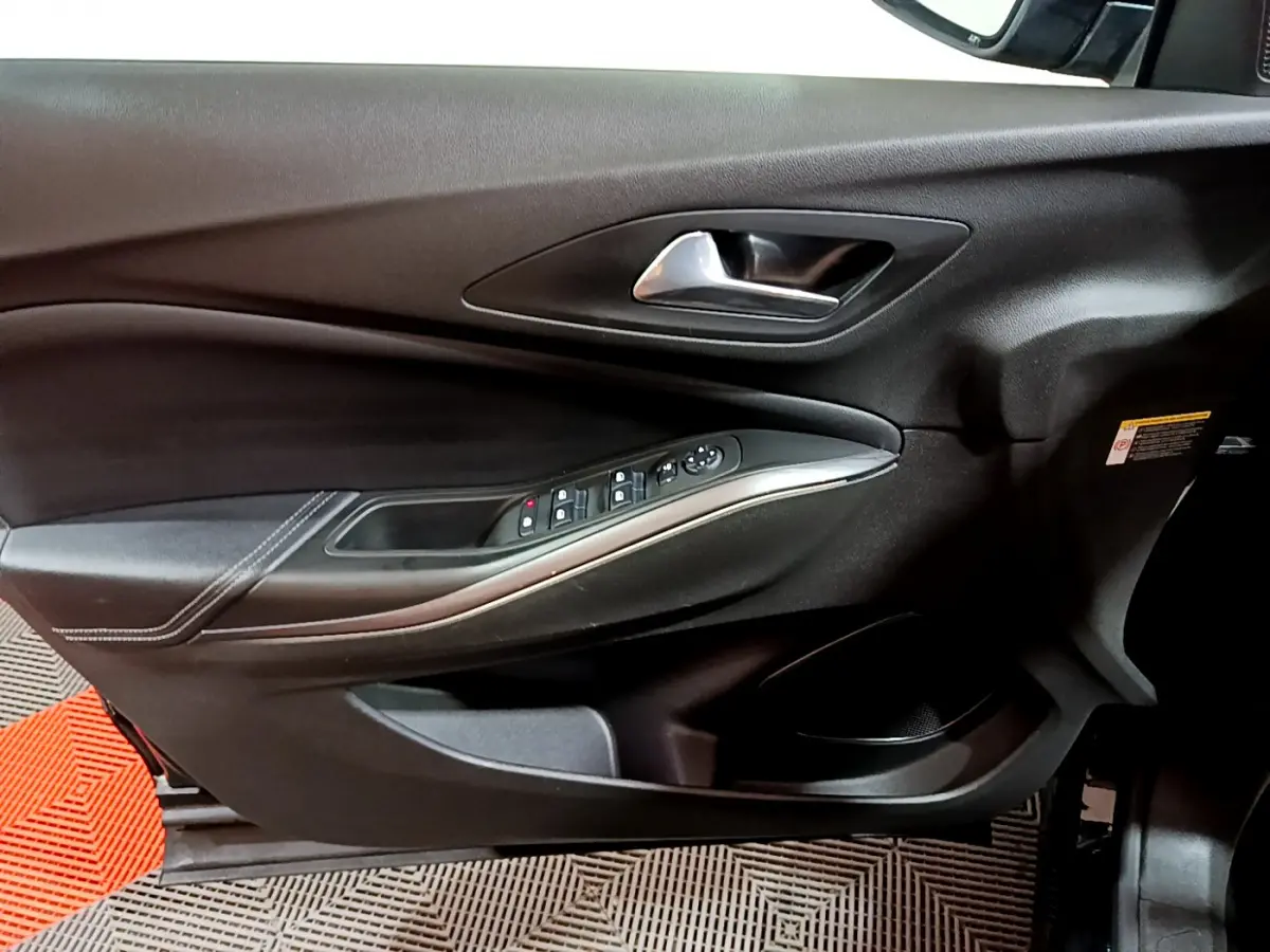 Gros plan sur la porte intérieure côté conducteur de l'Opel Grandland X noir, avec commandes électriques et poignée argentée.