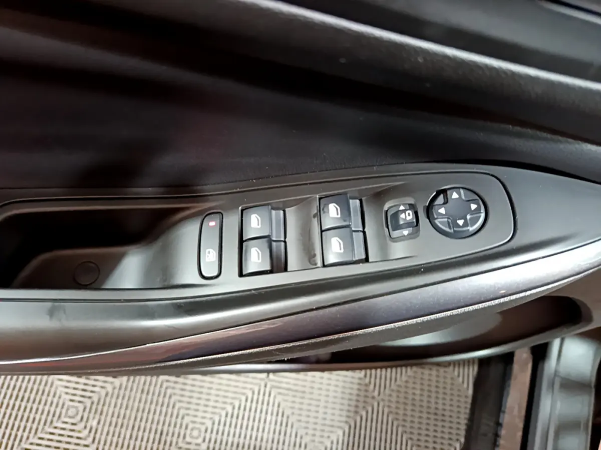 Gros plan sur les commandes des vitres et rétroviseurs côté conducteur d'un Opel Grandland X noir 2021.