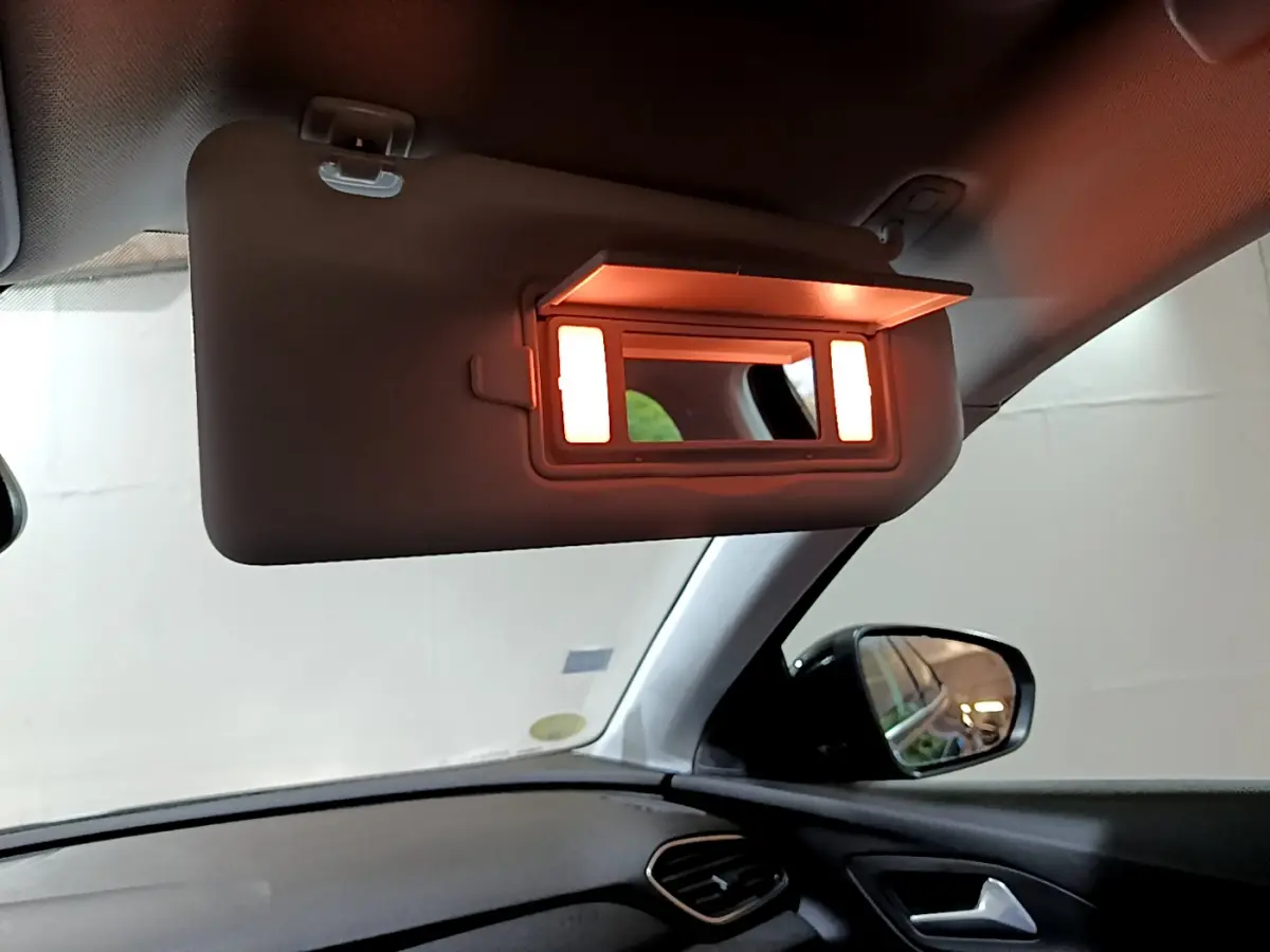 Miroir de courtoisie éclairé sur pare-soleil côté conducteur dans l'habitacle noir d'un Opel Grandland X 2021.