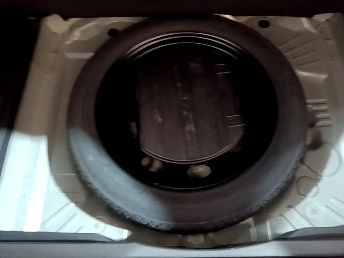 Roue de secours noire vue de dessus dans le compartiment de coffre d'un Opel Grandland X noir 2021.