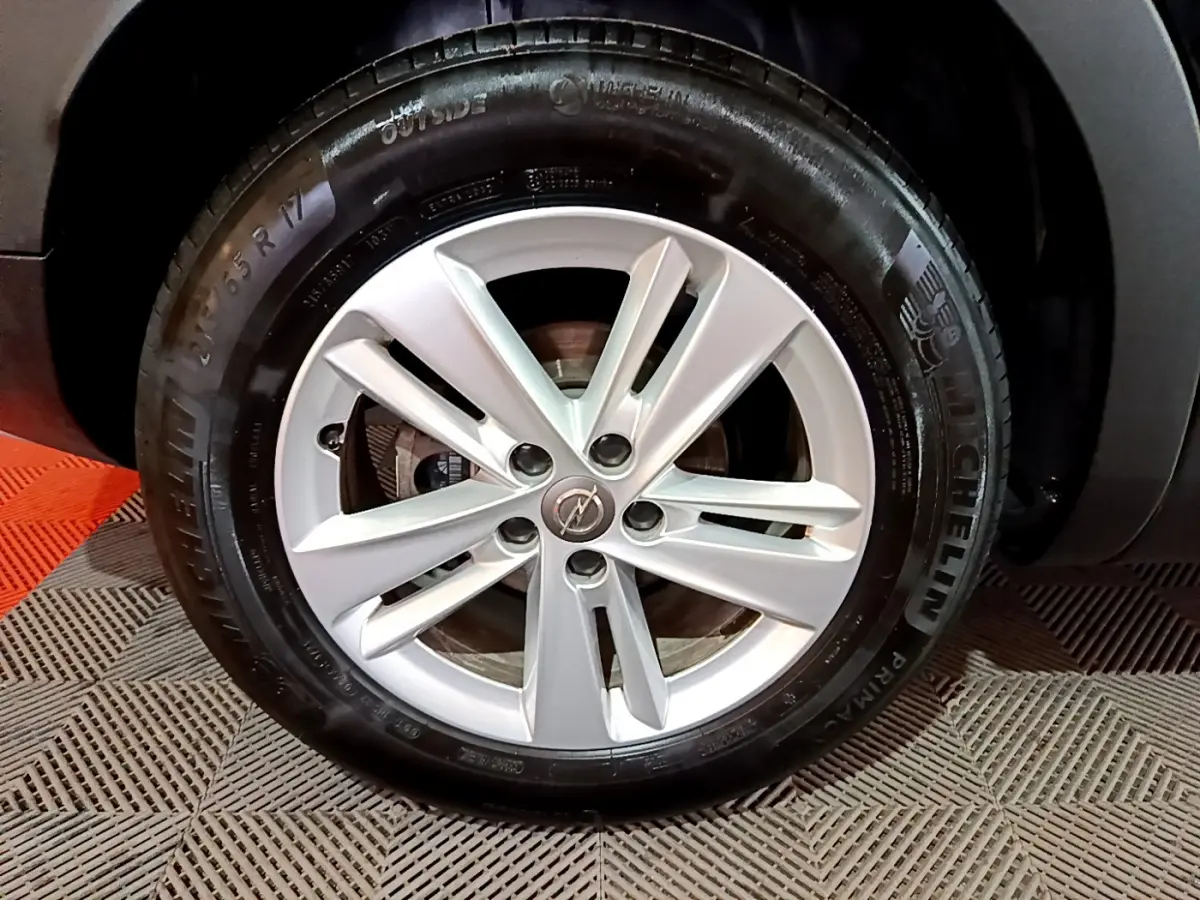 Gros plan sur la roue avant droite de l'Opel Grandland X noir avec jante alliage et pneu Michelin.
