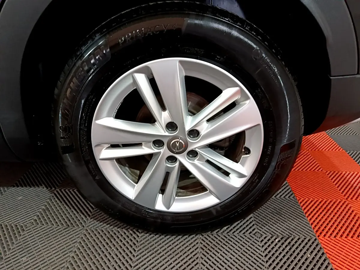 Gros plan sur la jante argentée et le pneu Michelin d'un Opel Grandland X noir, vue côté roue arrière.