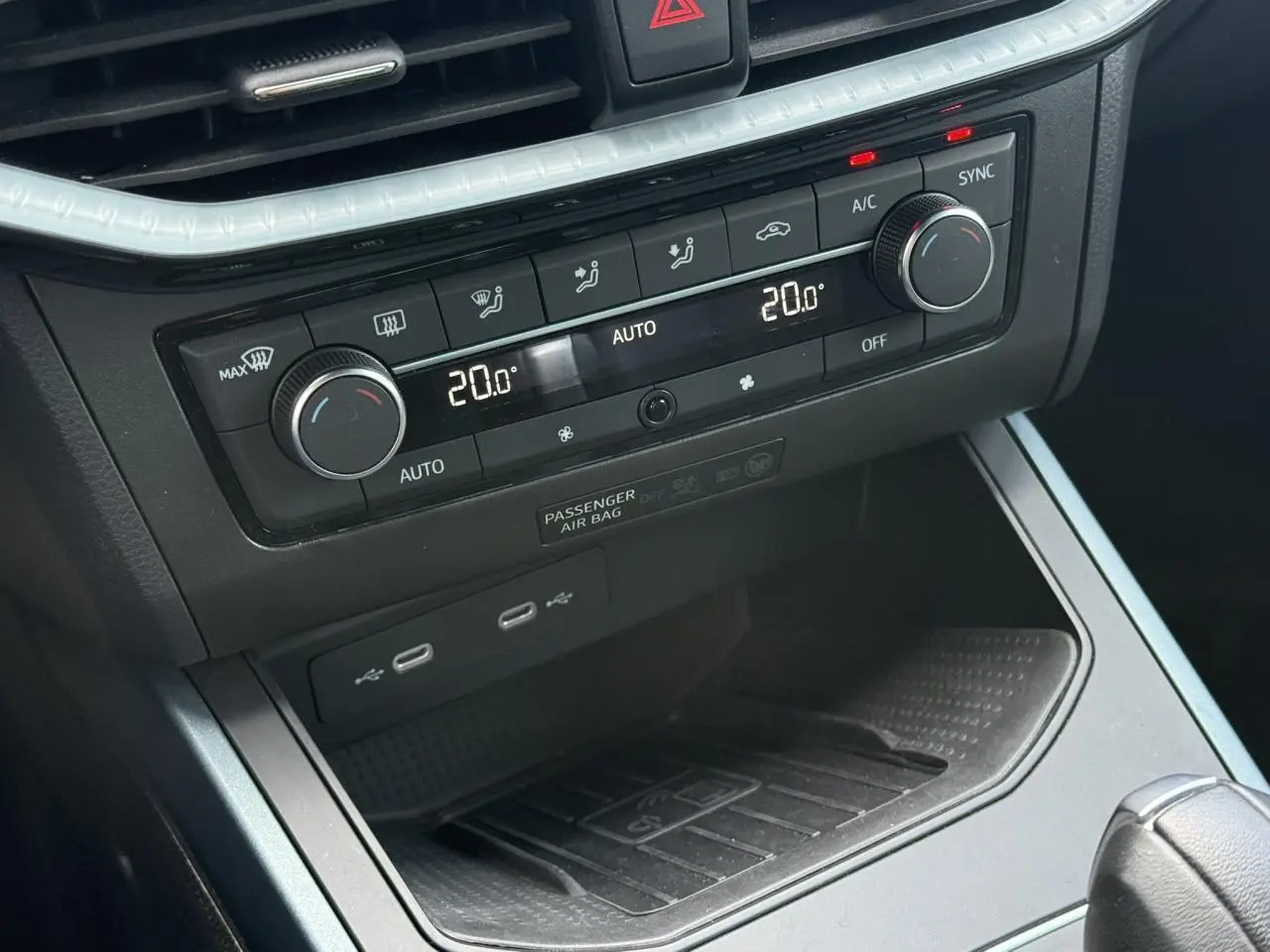Vue rapprochée de la console centrale du SEAT Arona 2025, avec commandes climatisation et ports USB visibles.