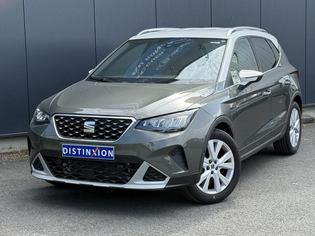 SEAT Arona Gris Cliff vue 3/4 avant droit, calandre chromée et jantes alliage 17 pouces blanches.