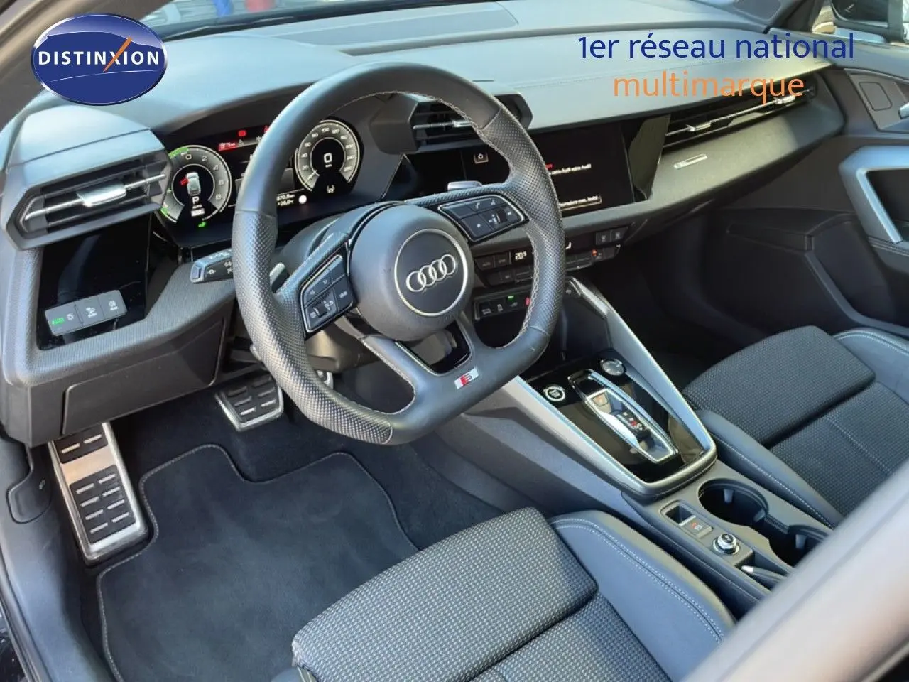 Vue intérieure côté conducteur de l'Audi A3 Sportback 40 TFSIe 2025, volant cuir perforé et console centrale moderne.