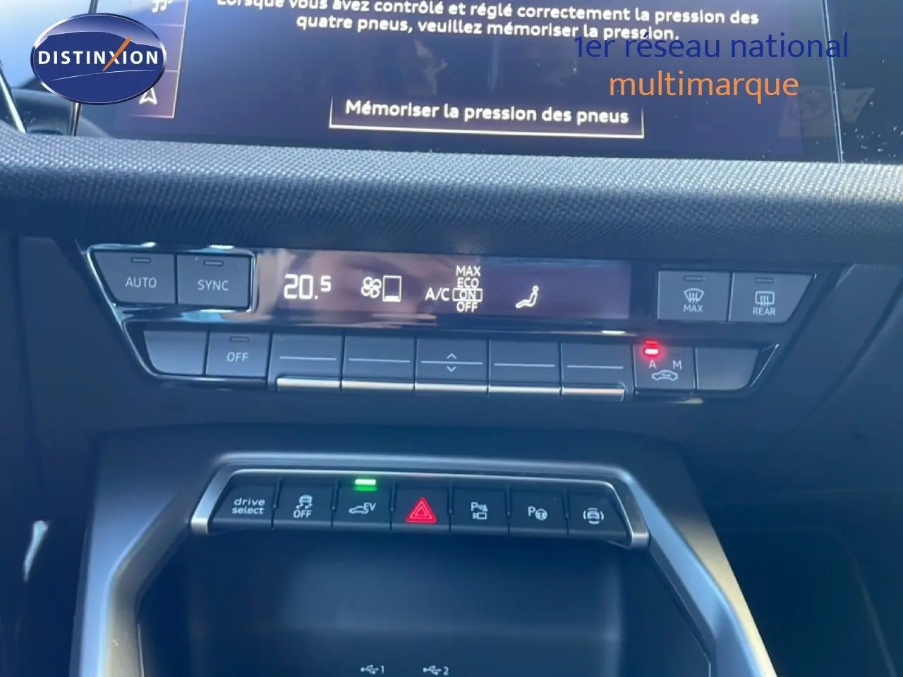 Vue rapprochée de la console centrale de l’Audi A3 Sportback noire, affichant les commandes climatisation et boutons multifonctions.