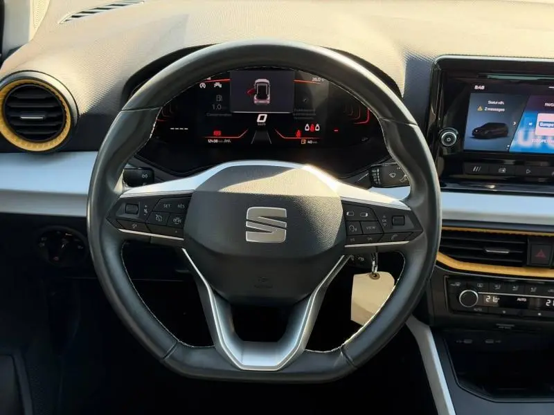 Vue rapprochée du volant cuir multifonction de la SEAT Arona 2025 avec tableau de bord numérique et détails en gris et noir.