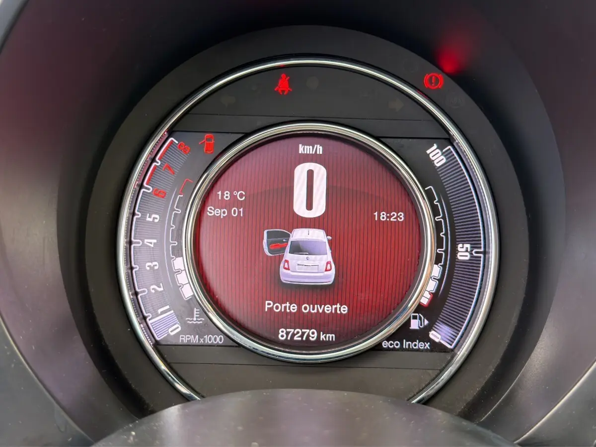 Affichage numérique central du tableau de bord de la Fiat 500 gris foncé, indiquant porte ouverte et vitesse zéro km/h.