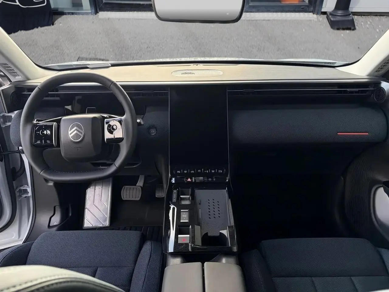 Vue intérieure frontale du tableau de bord et volant noir du Citroën C5 Aircross hybride 2026 avec console centrale épurée.