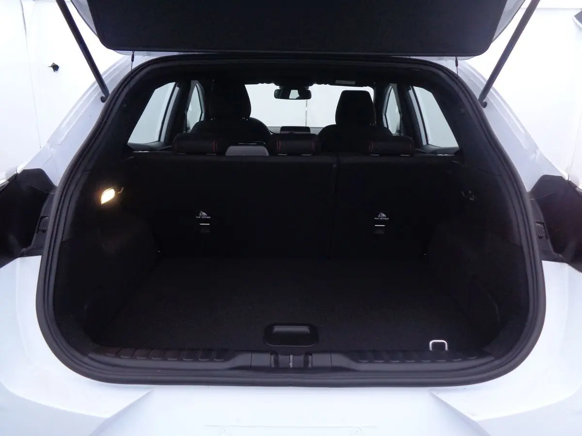 Coffre ouvert d'un Ford Puma blanc 2022, vue arrière mettant en valeur l'espace de chargement et les sièges noirs.