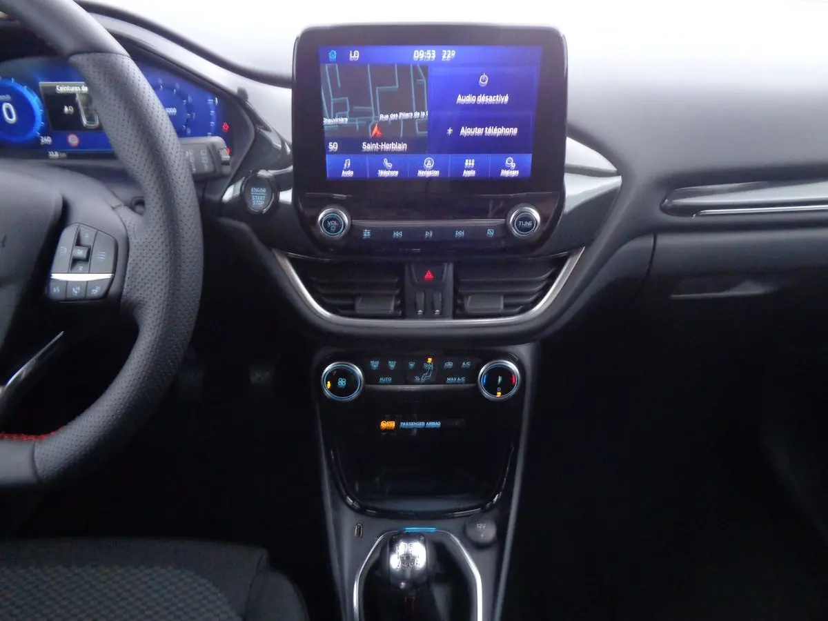 Vue centrale de l'intérieur du Ford Puma blanc 2022, avec écran tactile et levier de vitesses manuel visible.