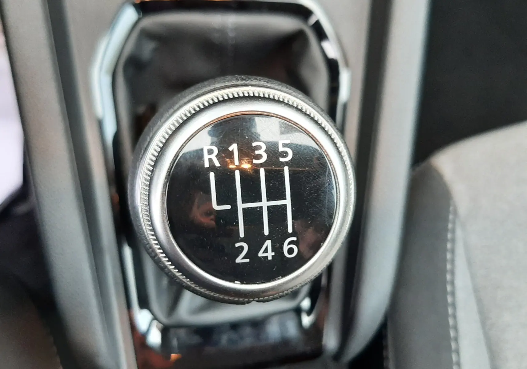 Gros plan sur le levier de vitesses manuel de la Renault Clio V TCE 90CH Evolution, intérieur gris tissu.