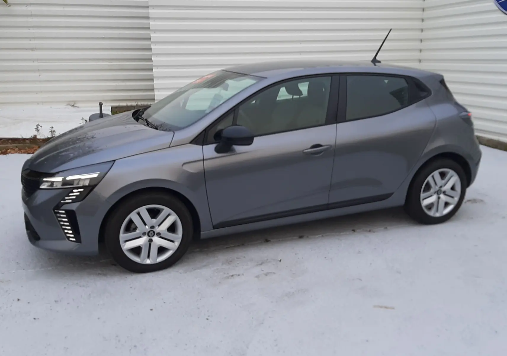 Renault Clio V TCE 90ch Evolution gris schiste vue de profil côté gauche, avec feux LED distinctifs avant.