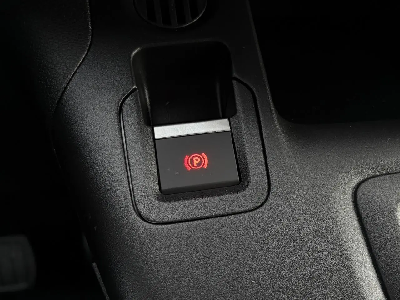 Gros plan sur le bouton de frein de stationnement électrique rouge dans l'habitacle noir du Citroën Berlingo Van XL 2025