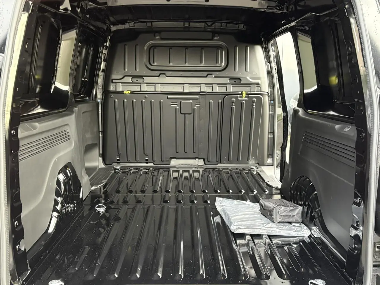 Vue intérieure arrière du Citroën Berlingo Van XL noir Perla, montrant l'espace de chargement tôlé et vide.