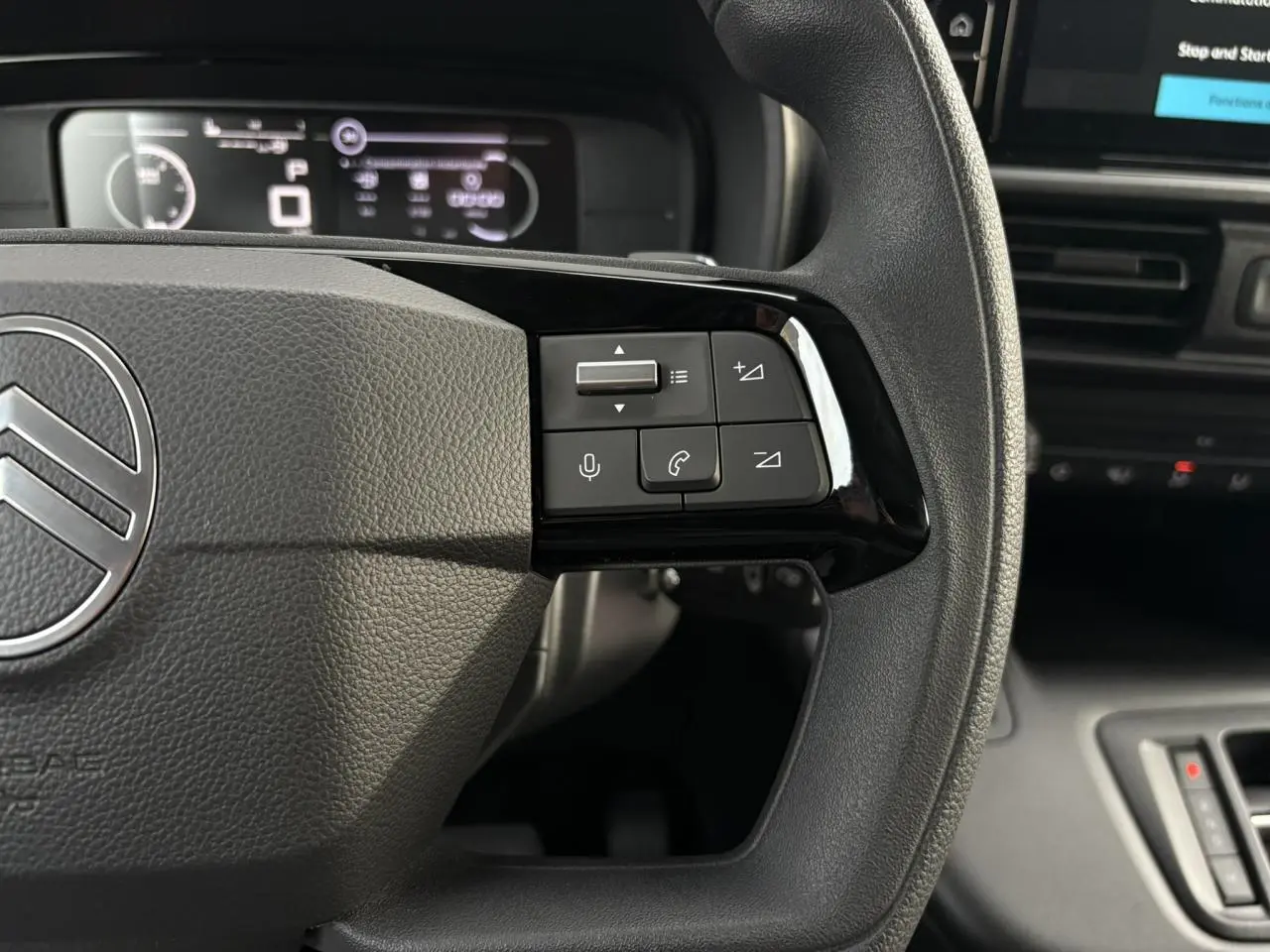 Gros plan sur le volant multifonctions côté droit du Citroën Berlingo Van XL 2025 avec commandes audio et téléphone.