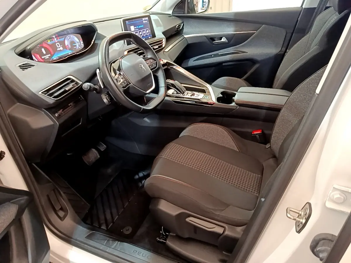 Intérieur côté conducteur du Peugeot 3008 blanc 2020, avec tableau de bord numérique et sièges tissu gris.