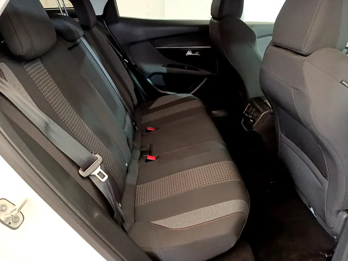 Vue côté gauche de la banquette arrière noire du Peugeot 3008 blanc, avec ceintures et appuie-têtes visibles.