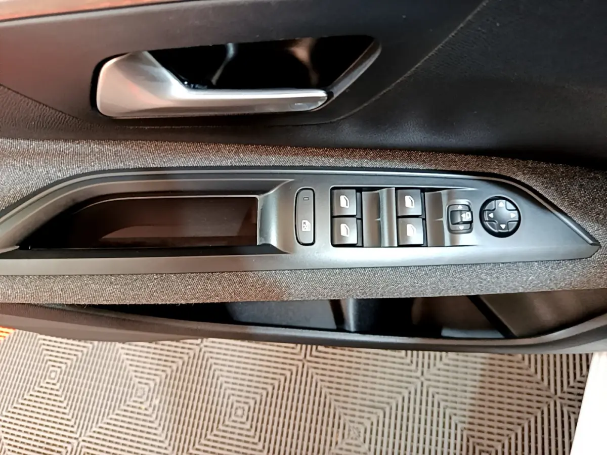 Vue rapprochée de la commande des vitres électriques et du verrouillage sur la porte côté conducteur du Peugeot 3008 blanc 2020.