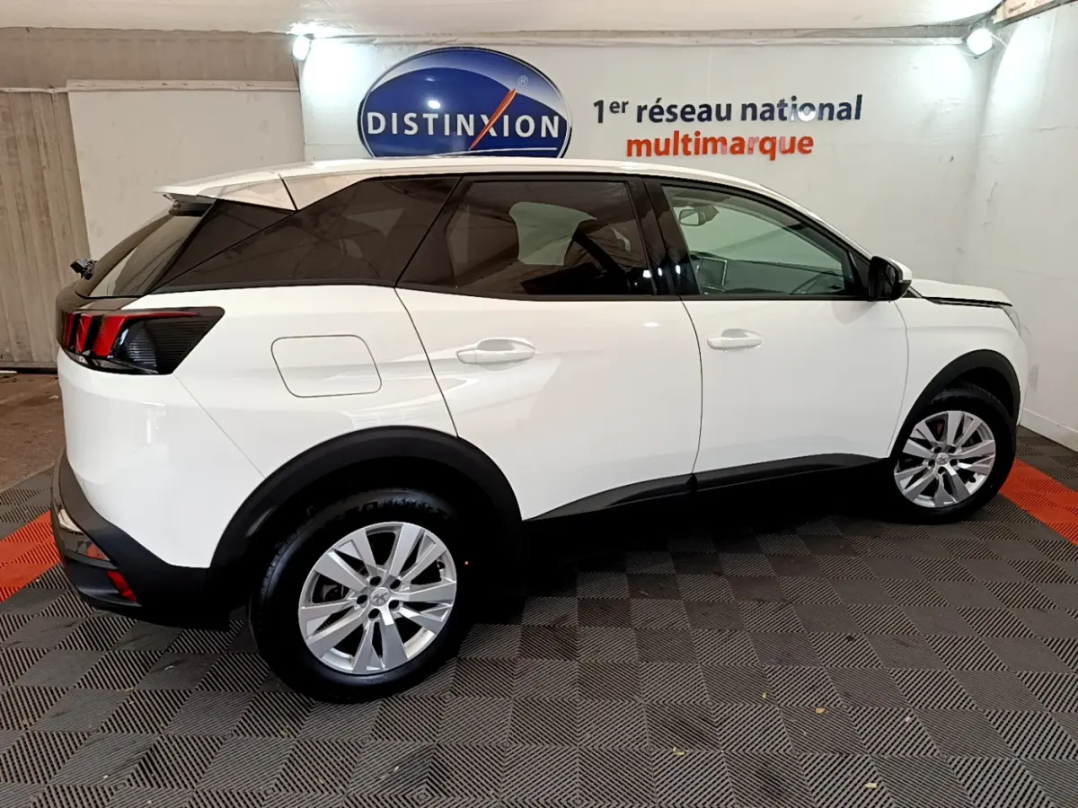 Peugeot 3008 blanc vue de profil côté gauche dans un showroom avec jantes alliage et vitres teintées.