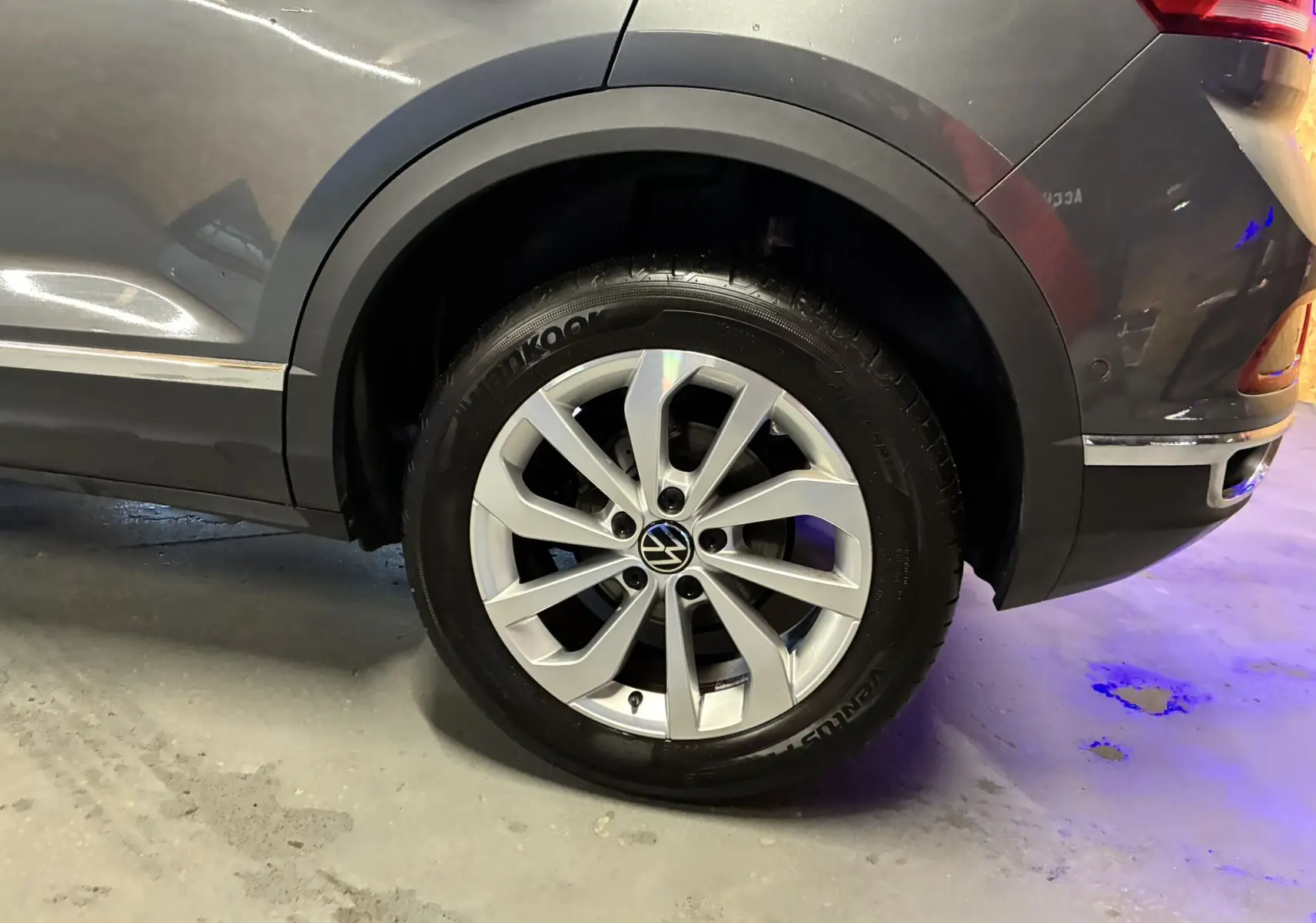Gros plan sur la roue arrière droite d’un Volkswagen T-Roc gris 2023, mettant en valeur la jante alliage et le pneu Hankook.