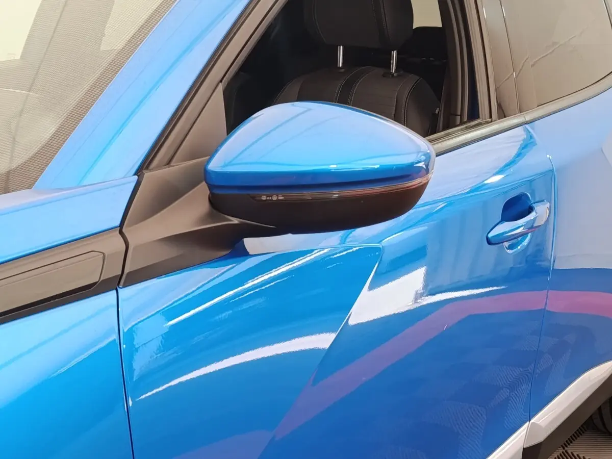 Gros plan sur le rétroviseur côté gauche bleu brillant d’un Peugeot 2008 PureTech 100 S&S Allure Pack 2021.