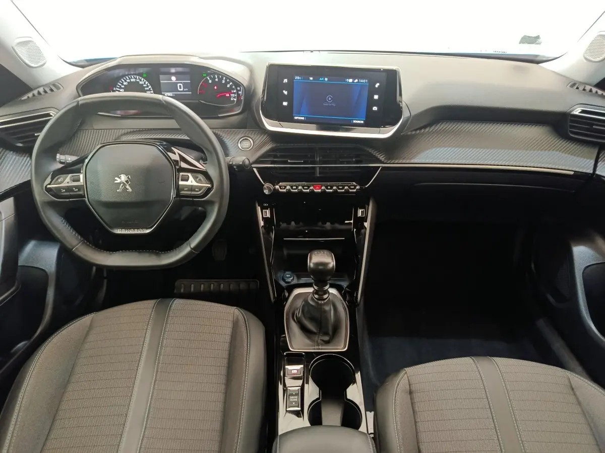 Vue intérieure avant de la Peugeot 2008 2021 avec volant cuir multifonctions et écran tactile central.