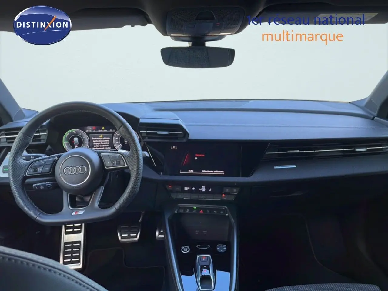 Vue intérieure frontale de l'Audi A3 Sportback 40 TFSIe S-Line 2025, tableau de bord et volant cuir noir avec affichage digital.