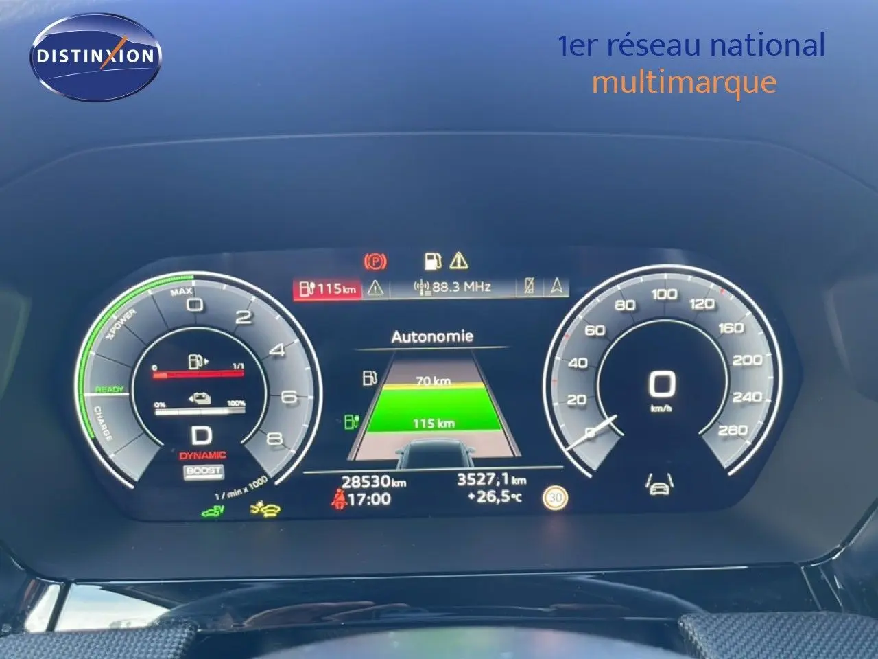 Tableau de bord numérique d'Audi A3 Sportback blanc, affichant l'autonomie et la vitesse à 0 km/h, vue frontale rapprochée.