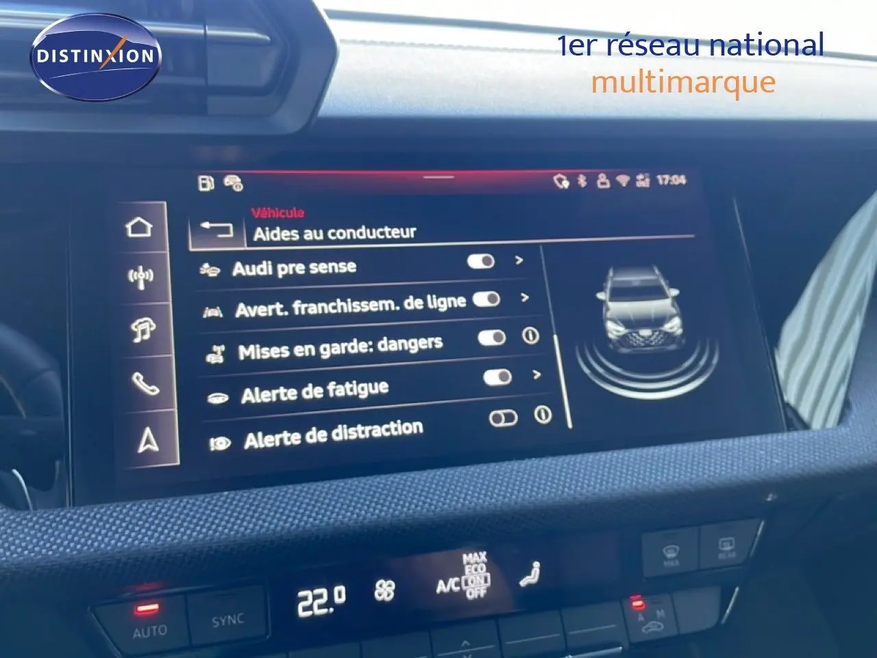 Écran central de l’Audi A3 Sportback blanc Ibis 2025 affichant les aides à la conduite, vue intérieure frontale.