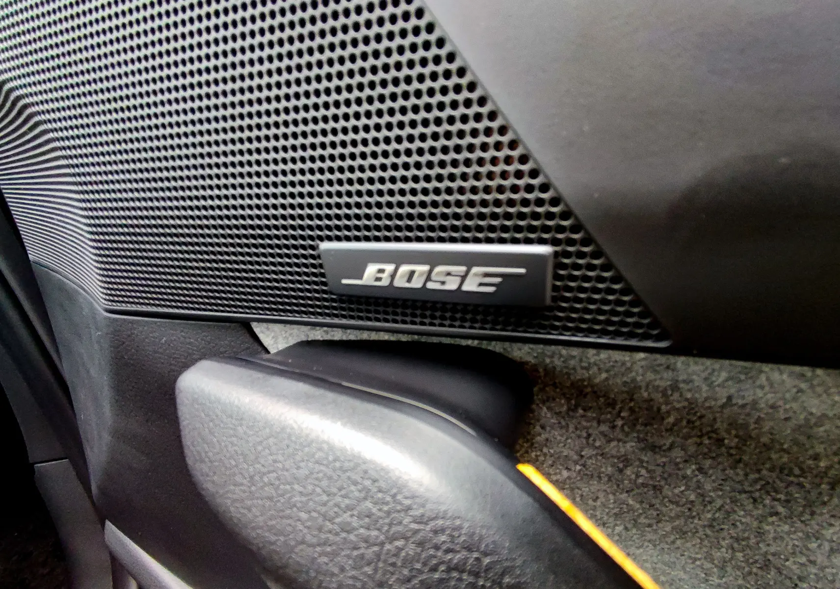 Gros plan sur l'enceinte Bose intégrée à la porte intérieure du Mazda MX-30 gris foncé 2023.