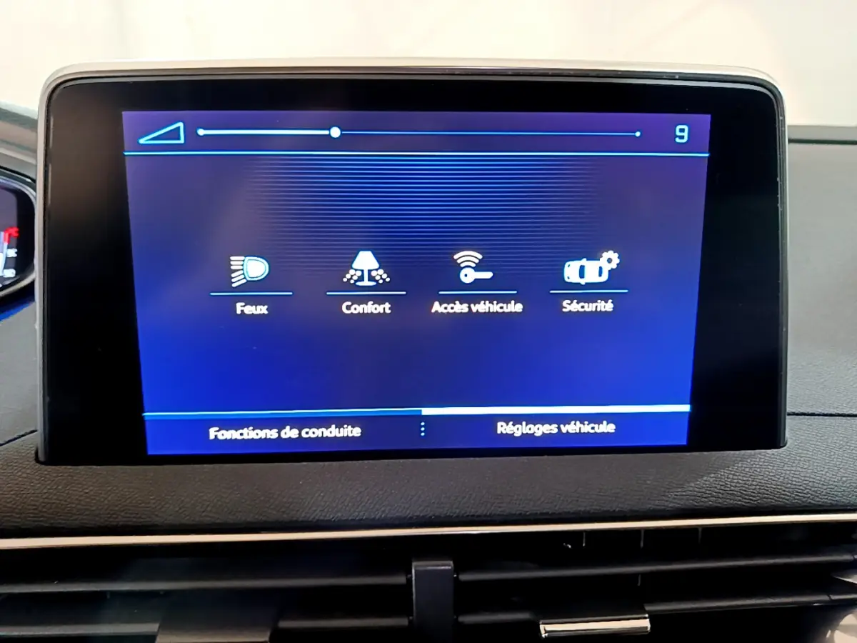 Écran tactile central du tableau de bord du Peugeot 5008 gris clair affichant les réglages véhicule et fonctions de conduite.