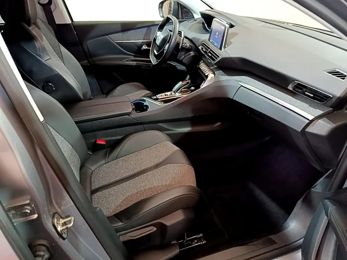 Intérieur avant droit du Peugeot 5008 gris clair 2020, sièges tissu et cuir, tableau de bord avec écran tactile central.