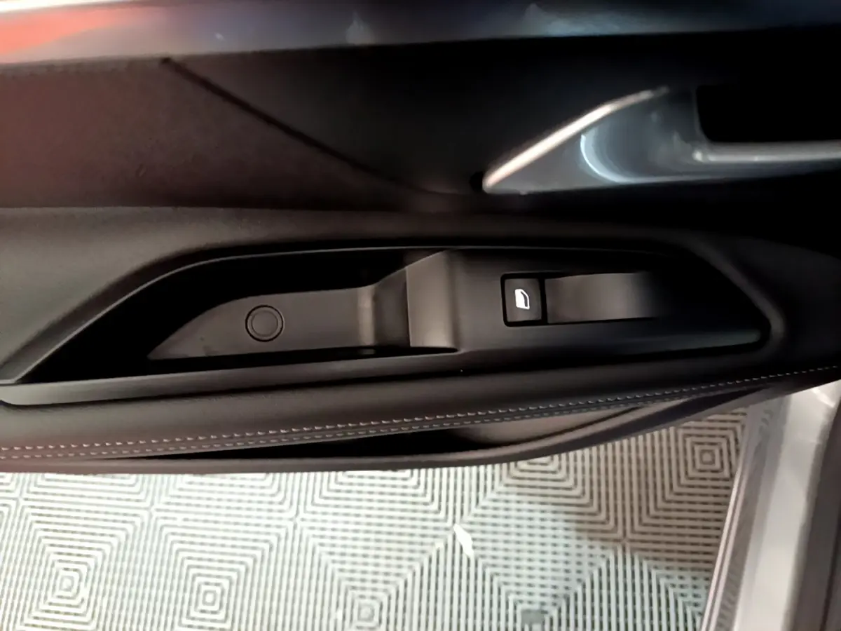 Poignée intérieure de porte côté gauche du Peugeot 5008 gris clair, avec bouton de verrouillage visible.