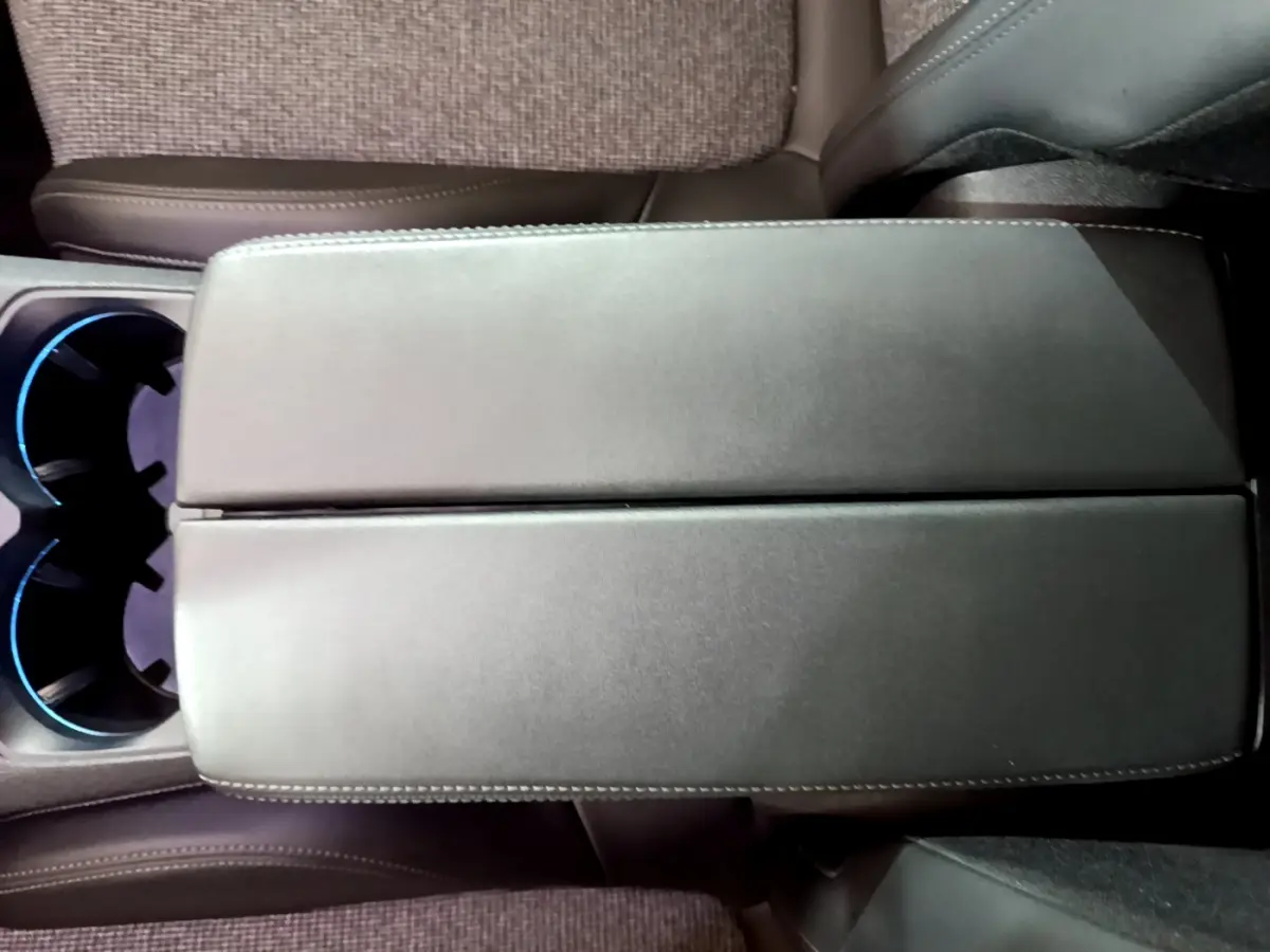 Vue rapprochée de l'accoudoir central en cuir noir et des porte-gobelets éclairés du Peugeot 5008 gris clair 2020.