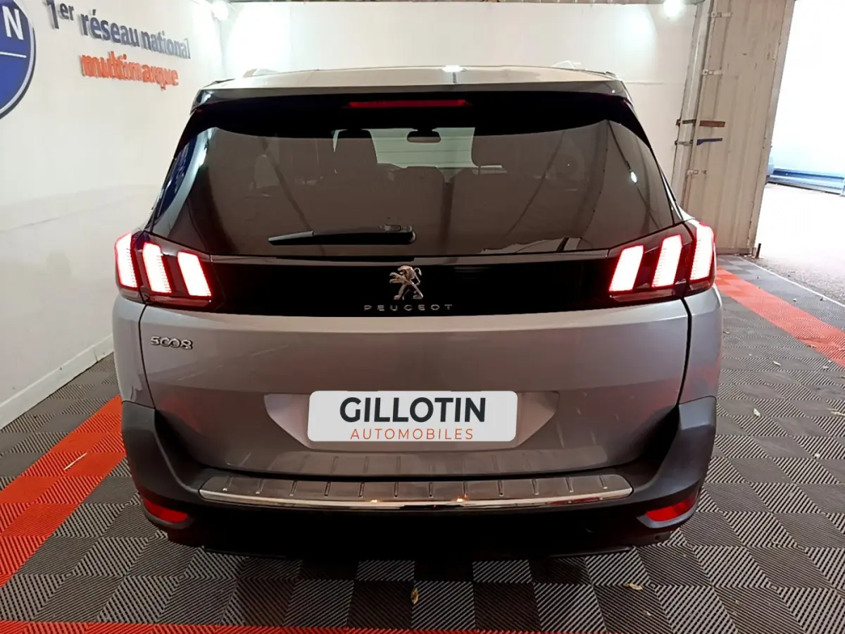 Vue arrière d'un Peugeot 5008 gris clair avec feux LED caractéristiques et logo au centre du hayon.