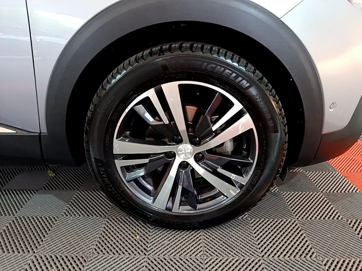 Gros plan sur la roue avant droite gris clair du Peugeot 5008 avec jante alliage noir et argentée et pneu Michelin.