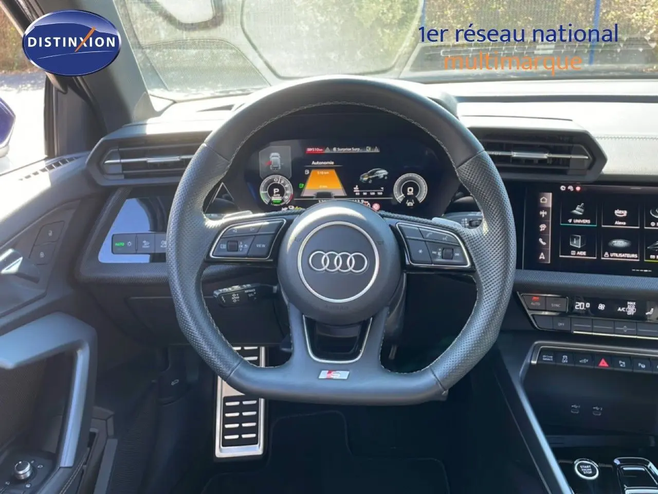 Intérieur Audi A3 Sportback 40 TFSIe 2025 vu du poste de conduite, volant S-Line, tableau de bord digital et écran tactile.