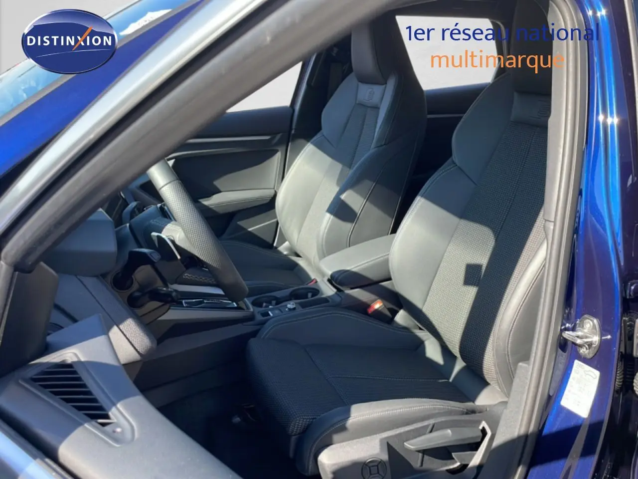 Vue intérieure côté conducteur de l'Audi A3 Sportback 2025 bleu Navarre, sièges sport S-Line en tissu gris noir.